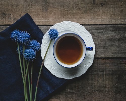 Warm cup of tea on a wooden table representing rest